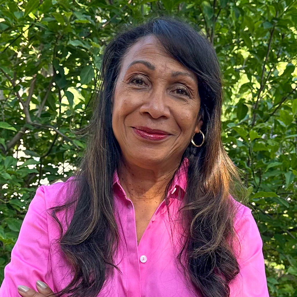Woman with hair pulled back wearing black glasses and a white striped suit jacket and a black shirt